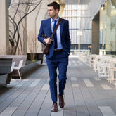 Model wearing navy blue tailored suit and tie paired with The CapToe Chestnut brown leather