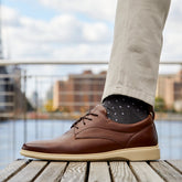 Original Chestnut & Cream close up photo of brown leather paired with black textured sock and light khaki pants