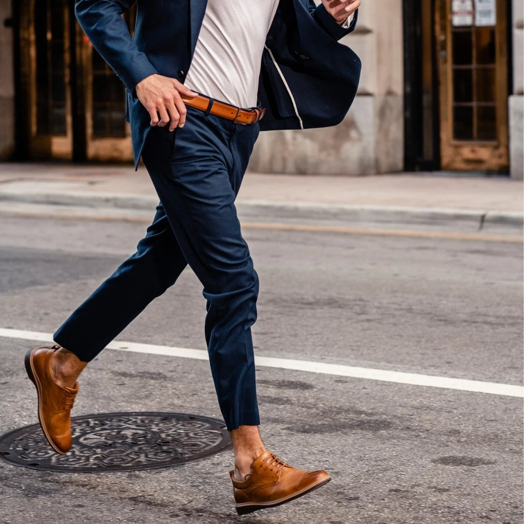 A man running on the street wearing a suit and dress shoes from Amberjack
