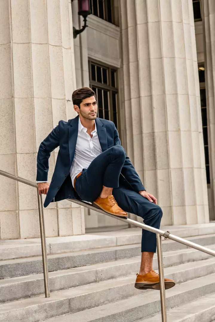 man sitting on a railing in business casual attire and Original Honey Amberjack shoes