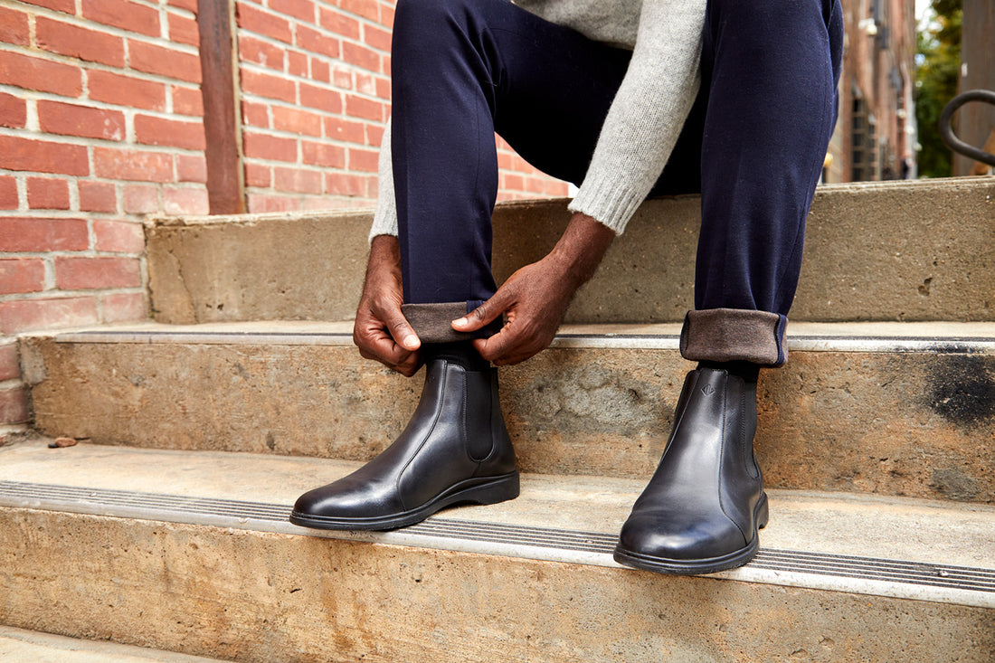 A man on stairs wearing black leather boots