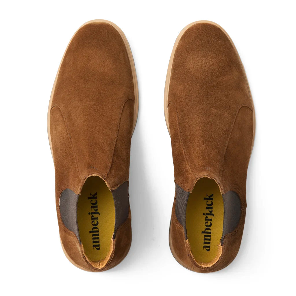 Top view of a pair of brown suede slip-on shoes labeled 'amberjack.'