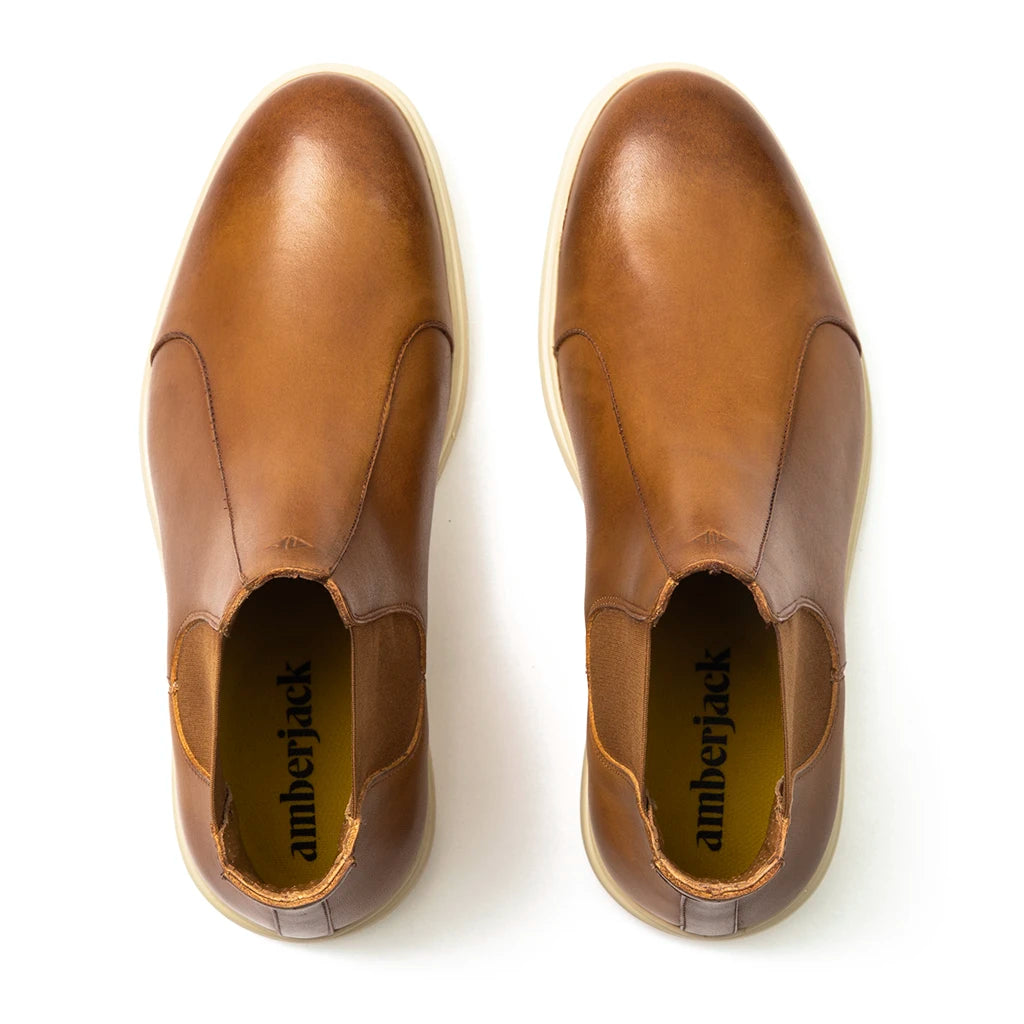 Top view of brown leather slip-on shoes with white soles.